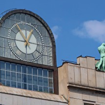 Clock and men on the top of the building opposite of Koruna Palace